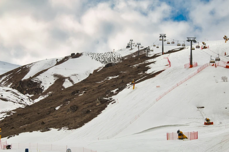 skiers are going down the hill in a cloudy sky