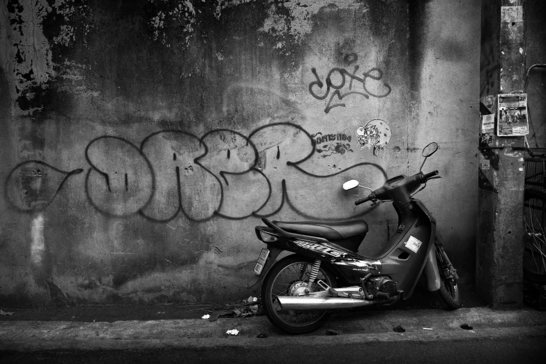 motorcycle parked next to graffiti covered wall