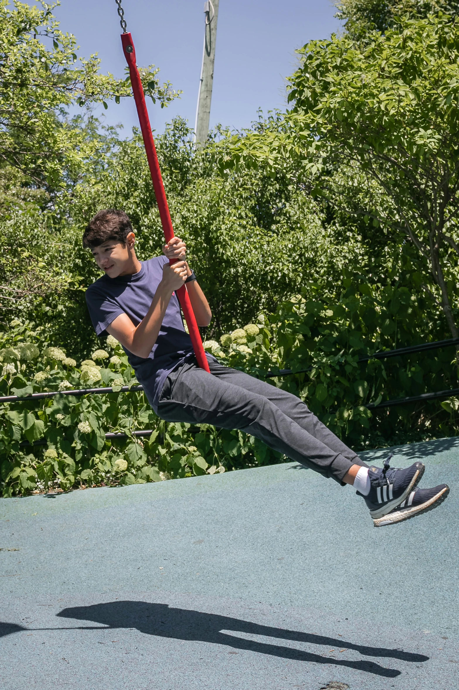 boy at the park swinging on a swing rope