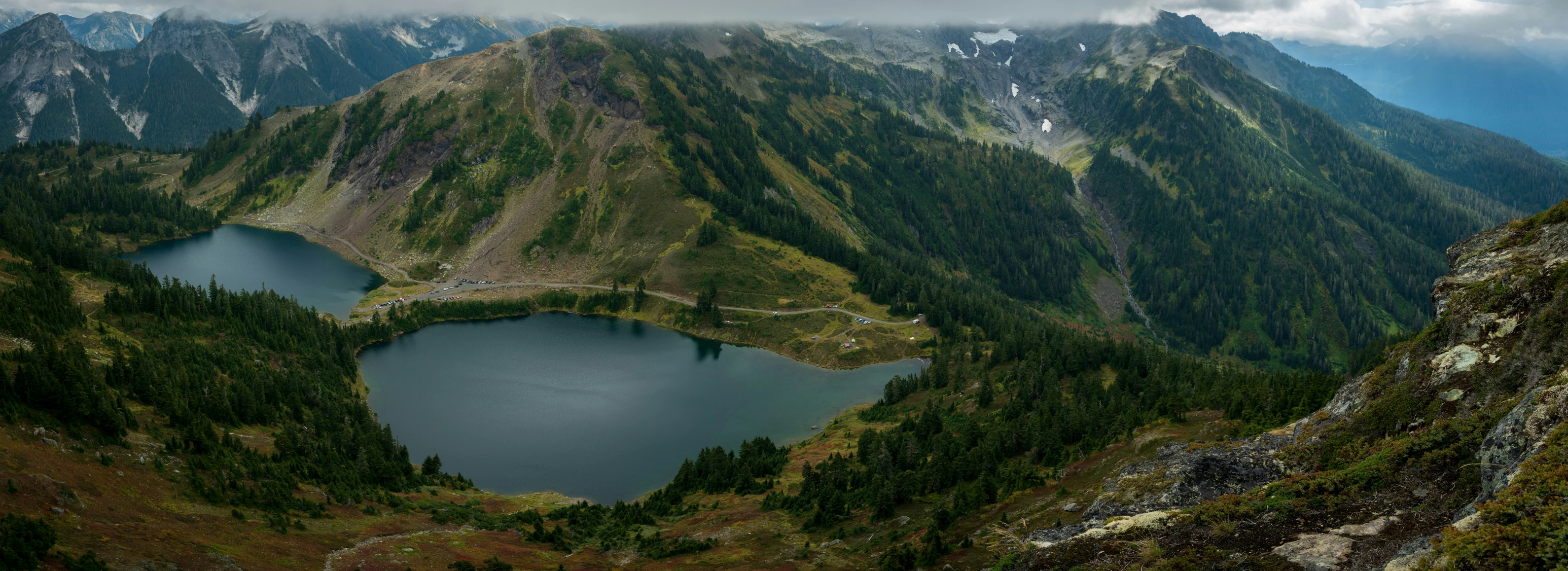 mountains surround a blue lake surrounded by greenery
