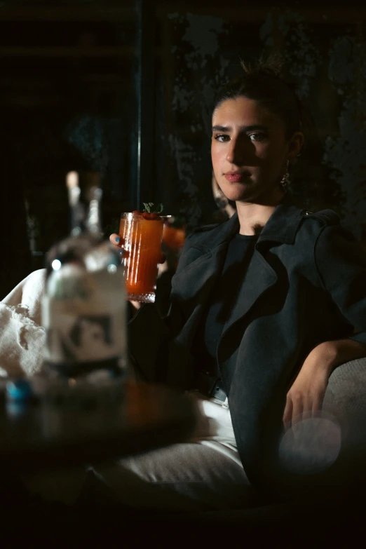 a woman in black shirt sitting in bed holding a beverage