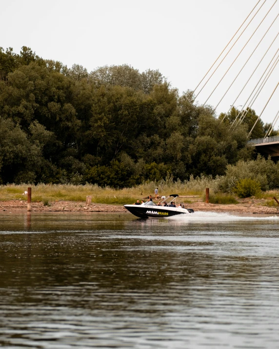 a boat moving along the water by trees