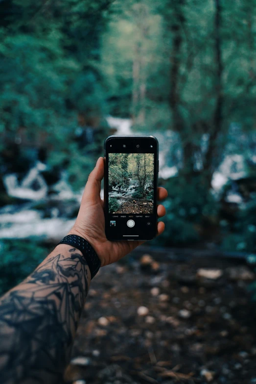 a hand holding up an iphone taking a po