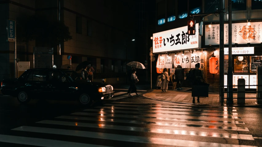 pedestrians on street at night with advertit on building