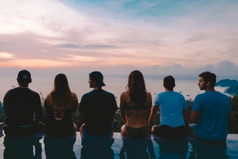 six people standing on the edge of a pool looking at water