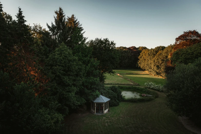 a white shelter near some trees in the evening