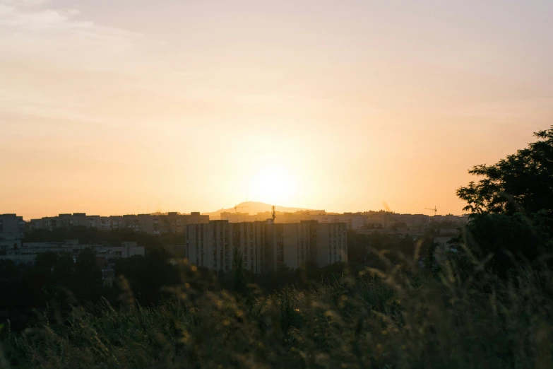 the setting sun shines over a city skyline with tall buildings