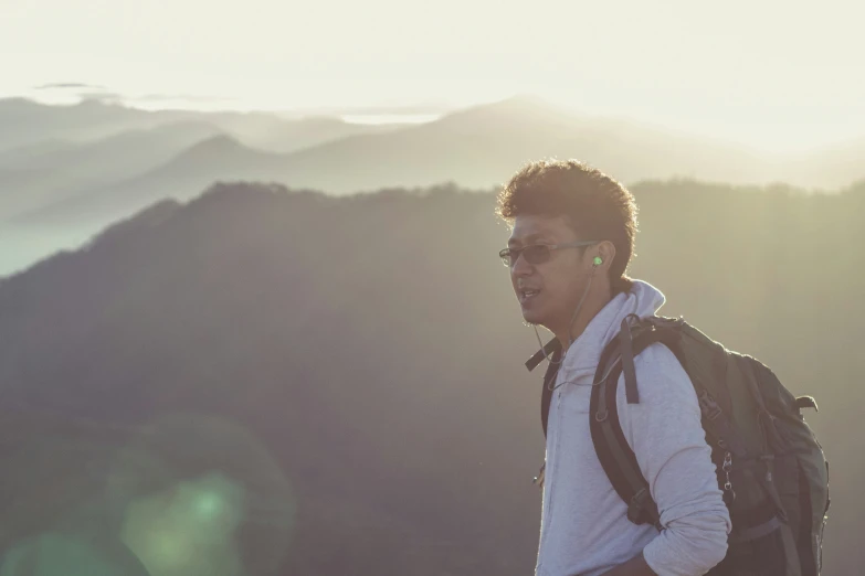 the man is wearing a backpack on the mountain