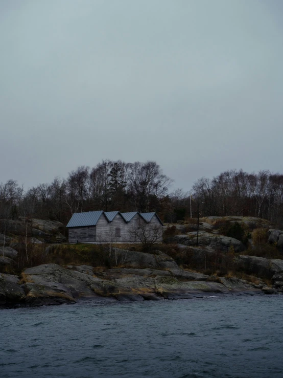 house next to the lake surrounded by rocks on the hillside