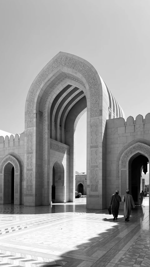 two people sitting in front of an arch shaped structure