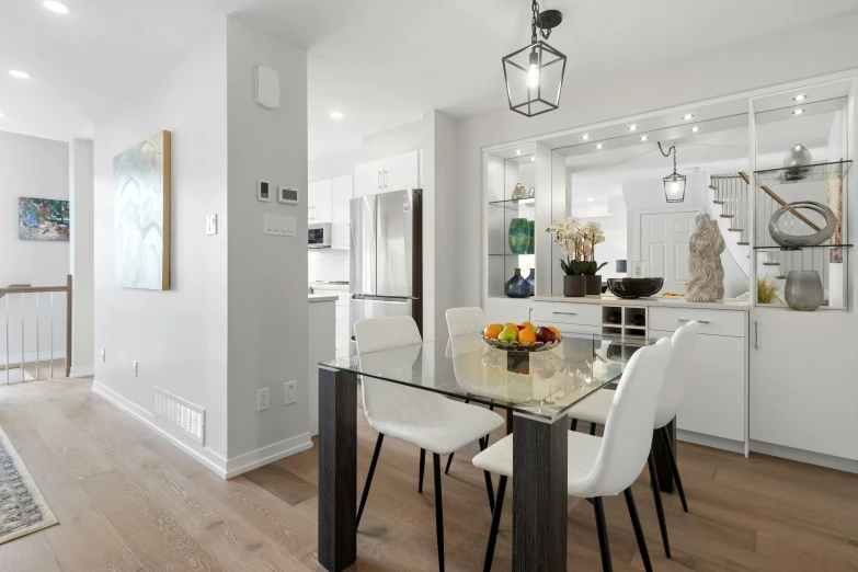 a dining area features all white chairs and a table with three dishes on it