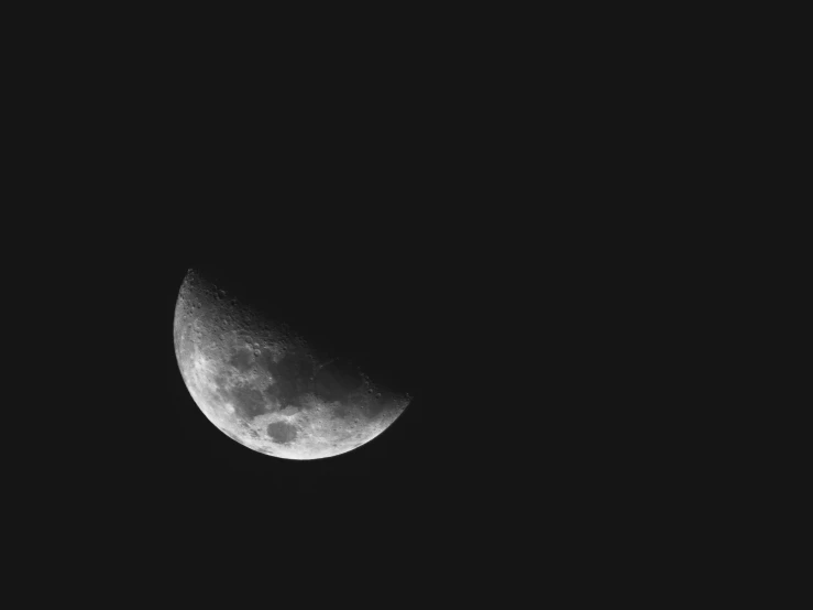 the half moon is very dark in the night sky