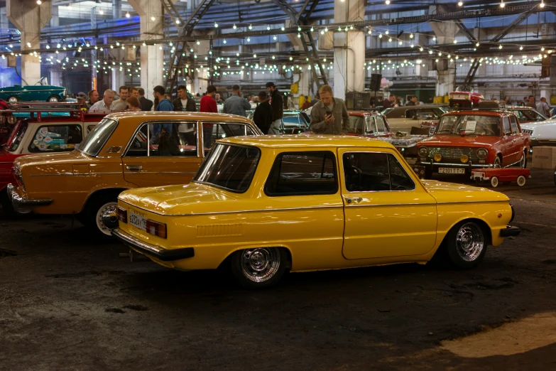 antique cars in a showroom with people looking at them