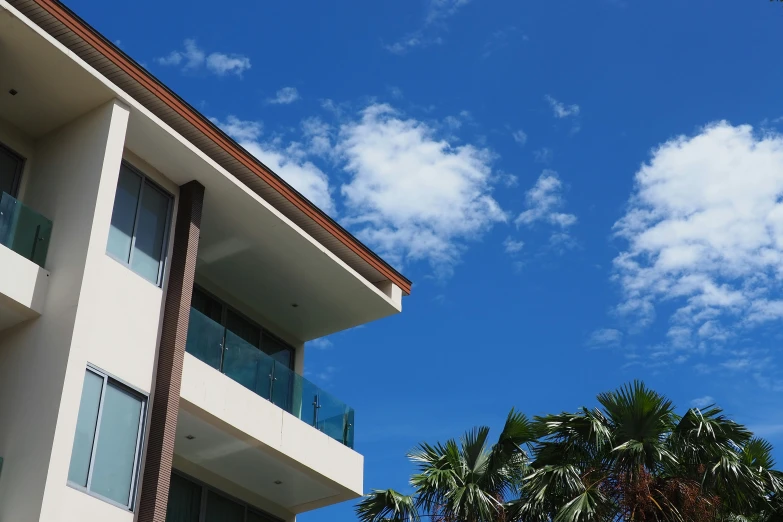 a large apartment building on a sunny day with trees