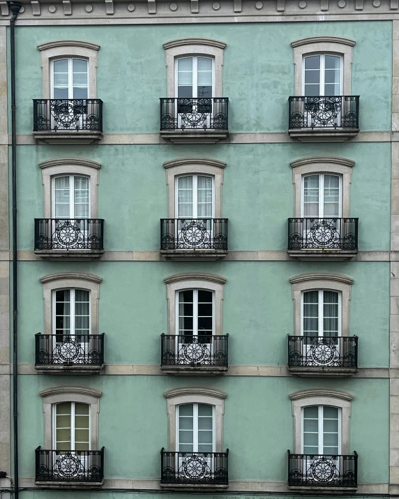 a green building with many balconies and small windows