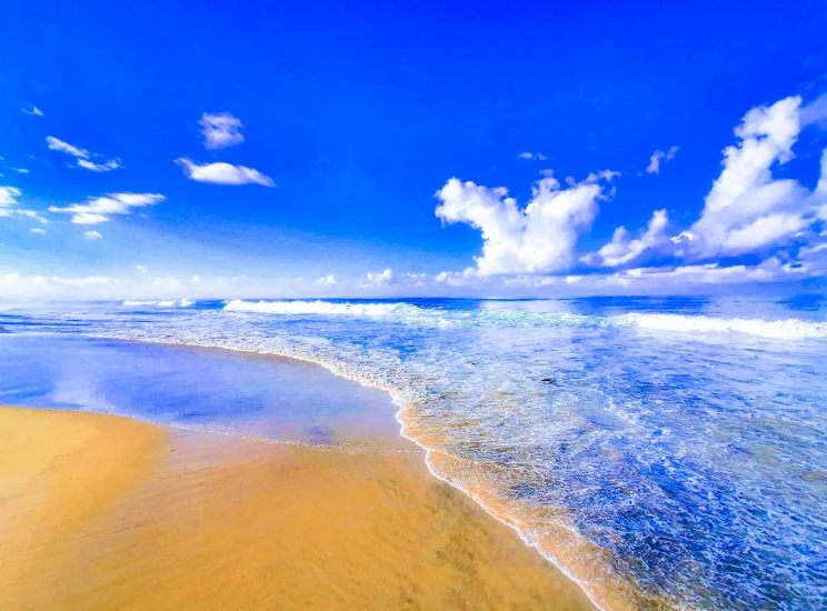 a sandy beach is shown under a blue sky with clouds