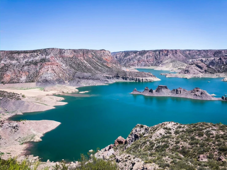 lake of many colors surrounded by mountains on a sunny day