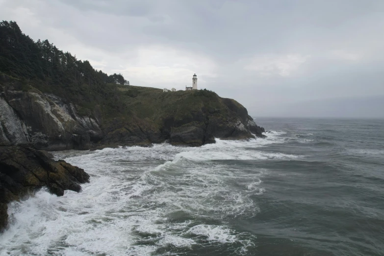 a lighthouse in the distance on the rocky shoreline