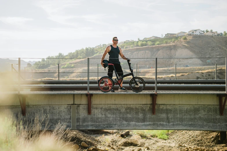 a man on a bike over a bridge