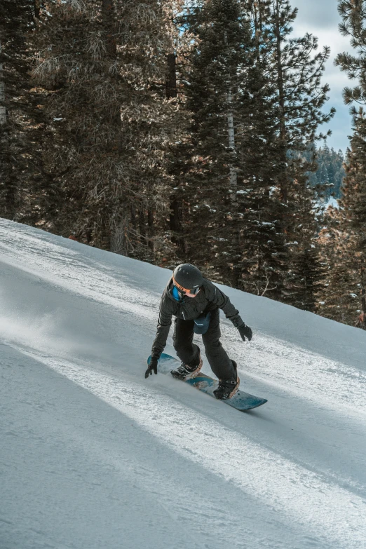 a snowboarder is going down the hill and is coming off