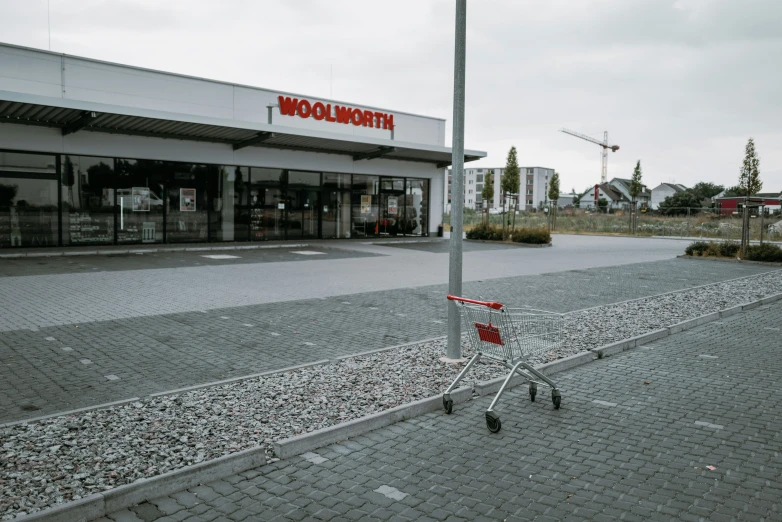 an abandoned shopping cart in front of a woompoo store