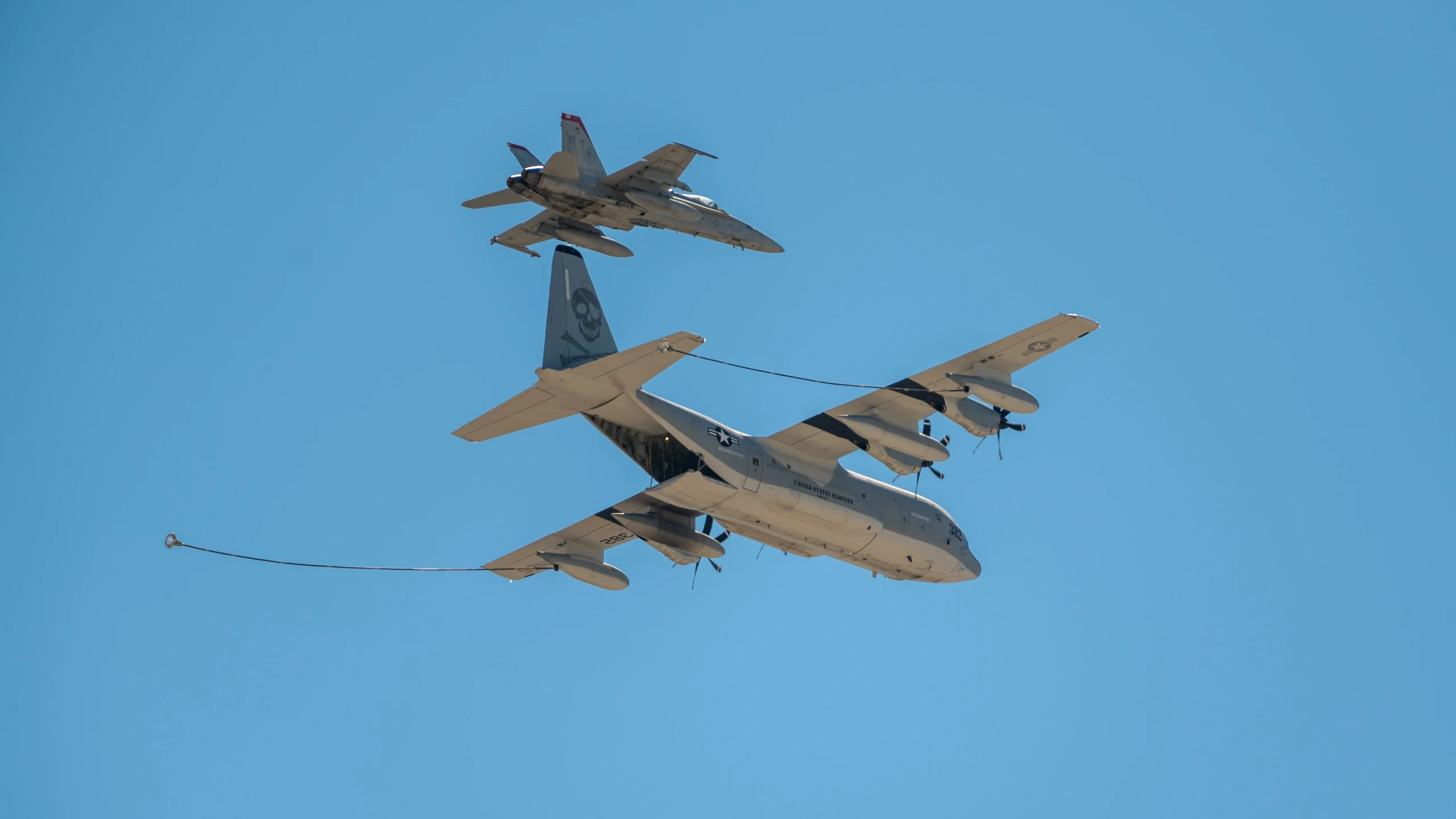 two military jets fly side by side in the air