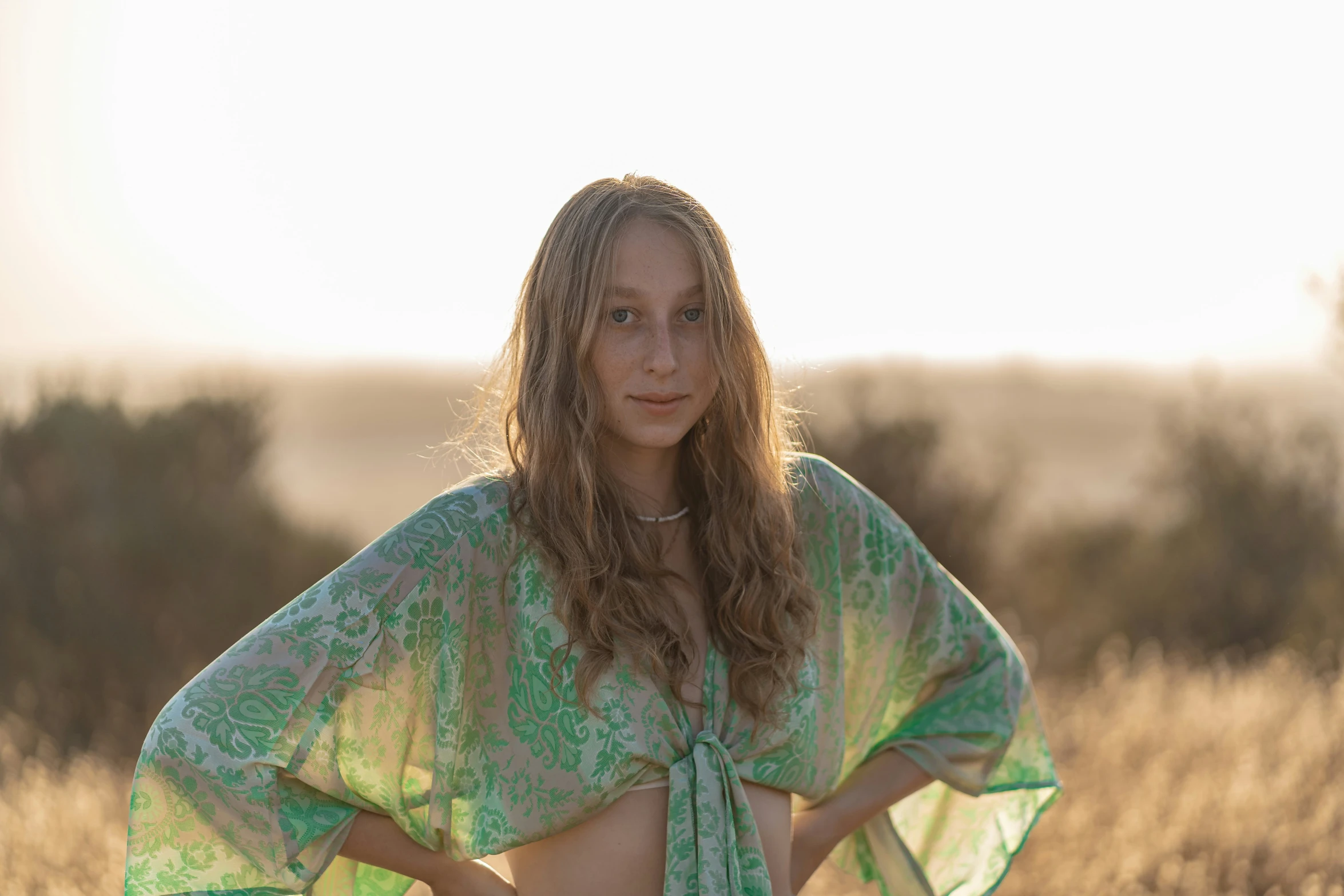 a female standing in a field posing for a picture