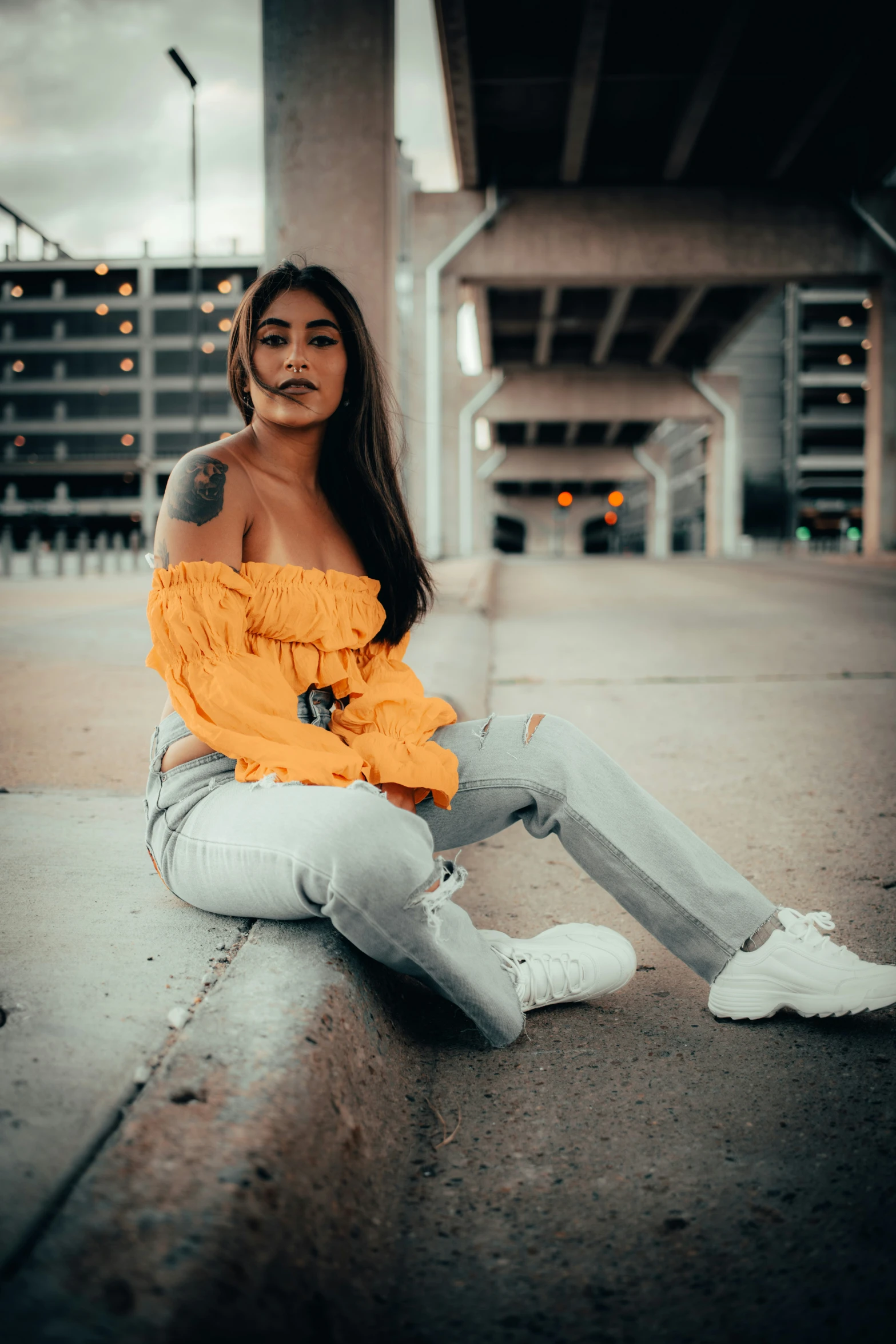 a girl in an orange blouse sits on the ground
