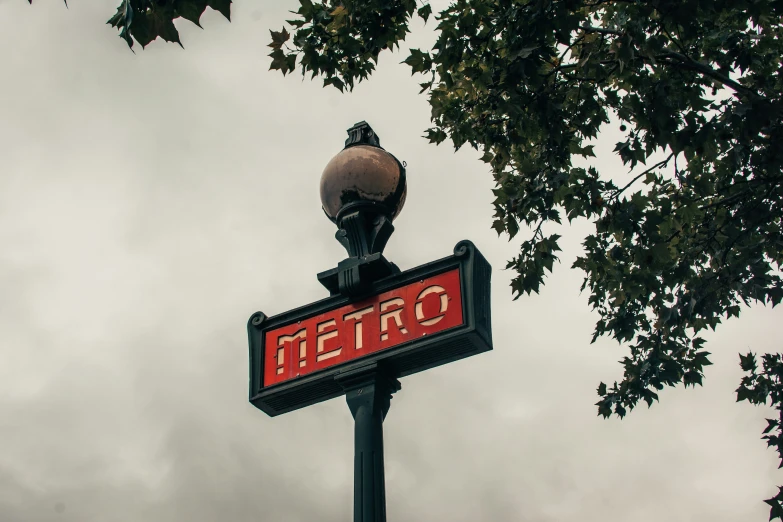 an open sign on a streetlight in front of a cloudy sky