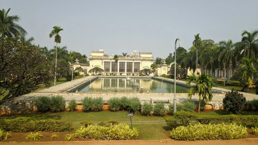 an old building with palm trees and grass around it