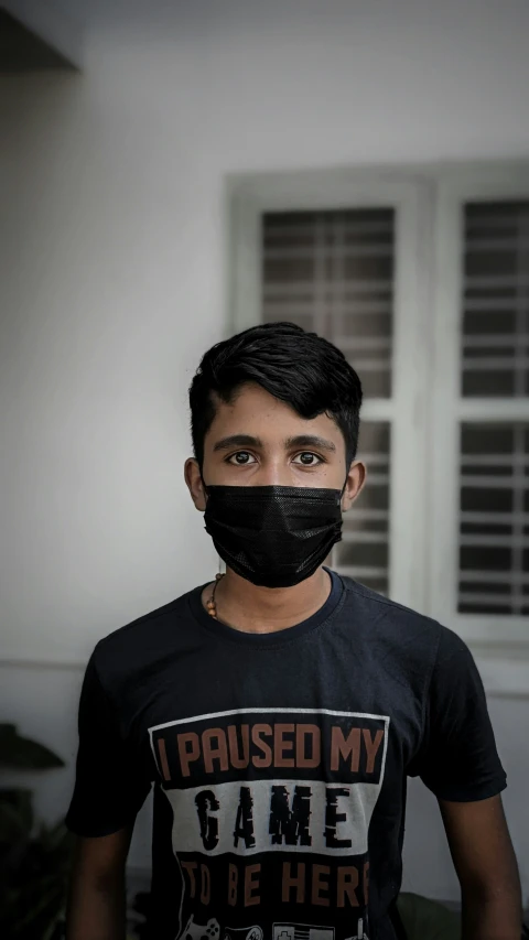 man wearing black shirt and mask with text on it