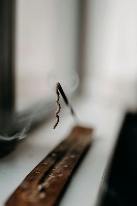 the pencil is stuck to the back of the wooden bench