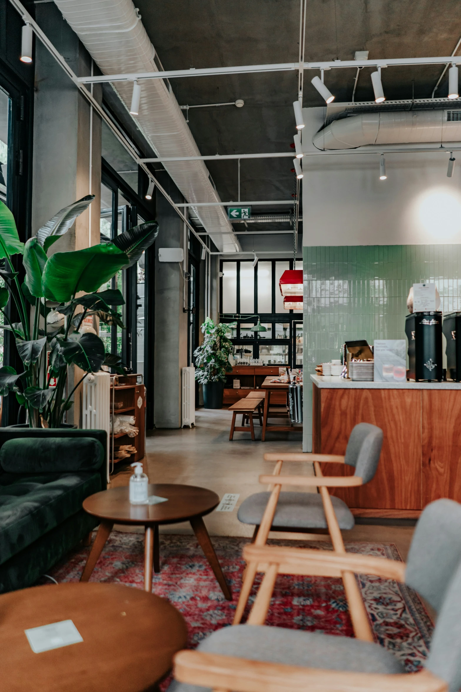 the lounge at a modern cafe has green walls