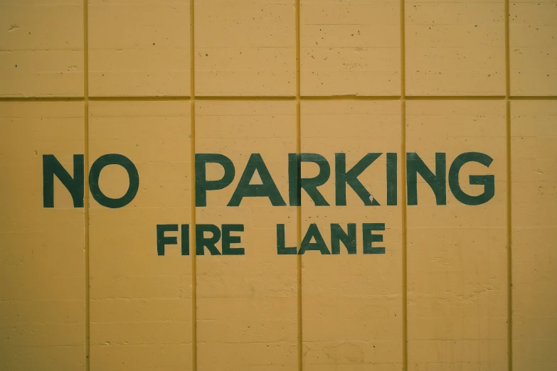 a black and yellow sign that says no parking fire lane