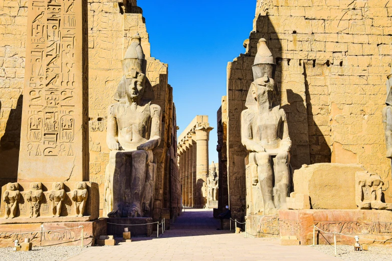 the huge, long, old, statues line a paved pathway