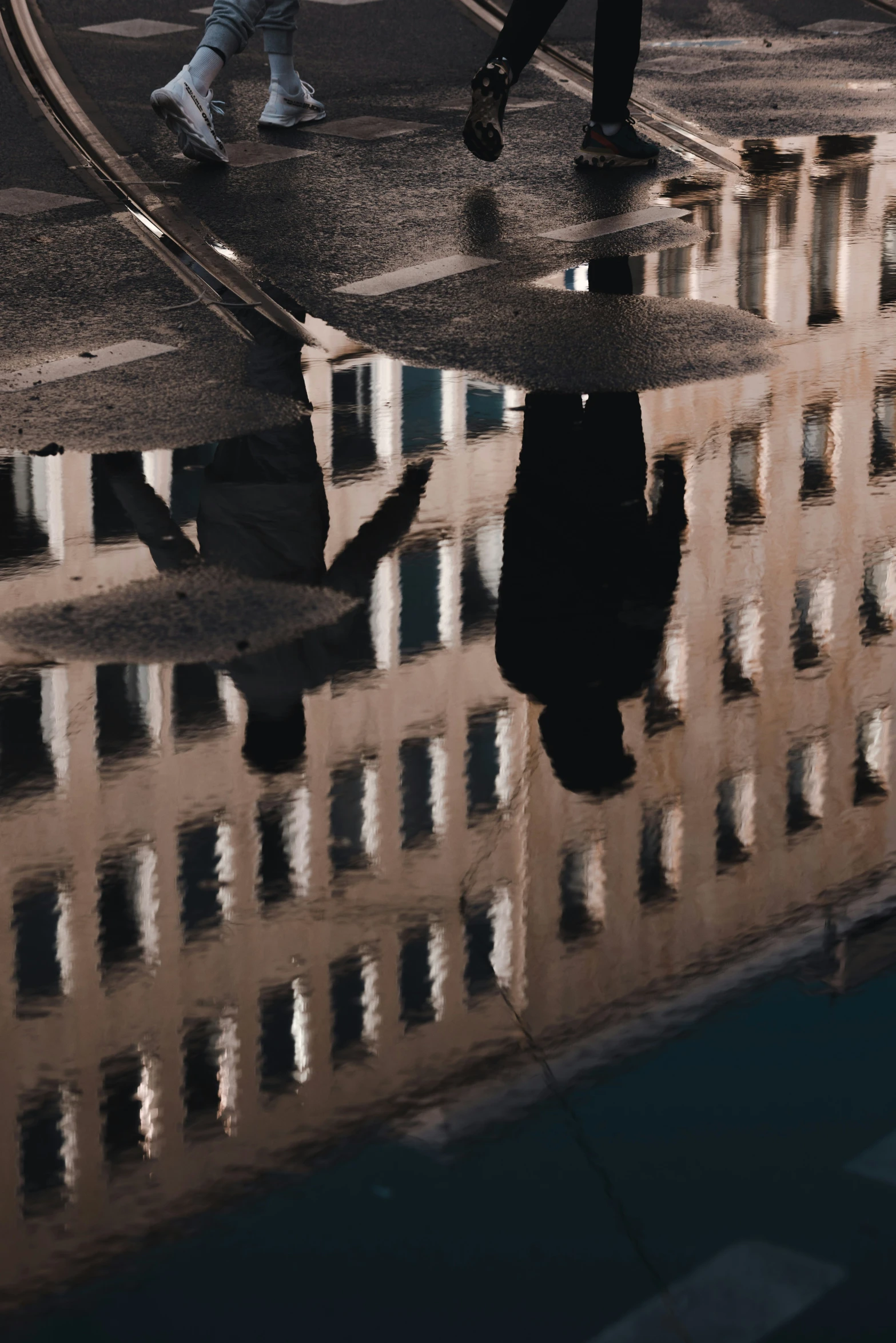 a pedestrian is reflected in a dle of water