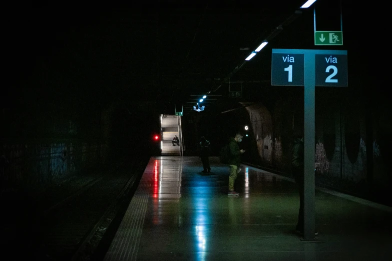 people waiting on the platform for a train at night