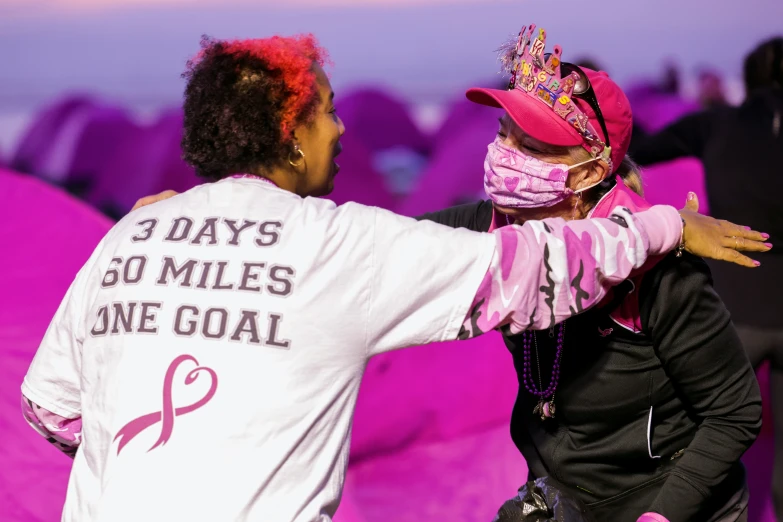 two women and a child with pink hair wearing masks and smiling