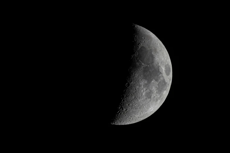 the moon is seen in the dark night sky