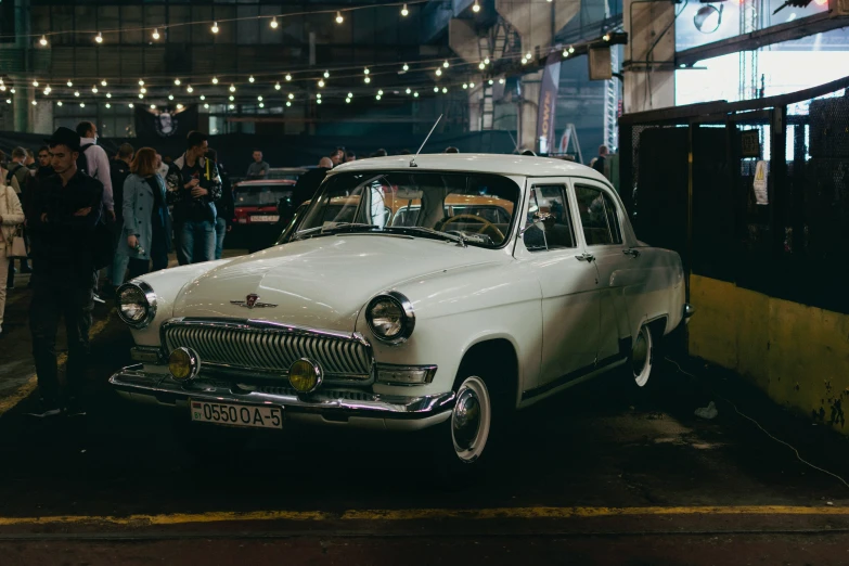 a classic white car is parked outside of a business