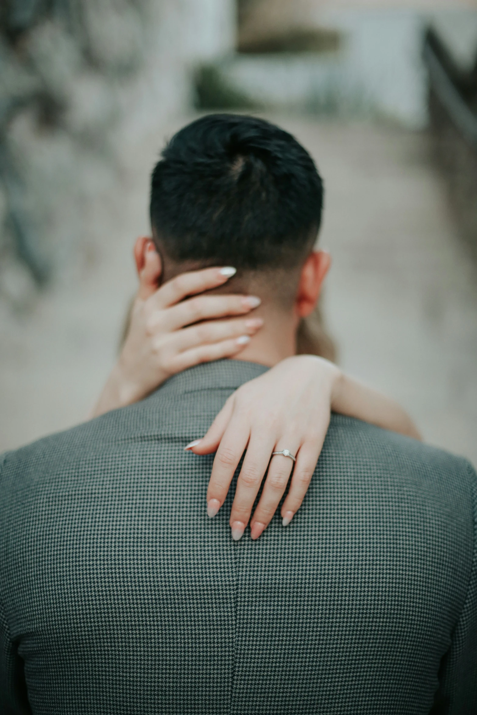 a woman hugging her man's back in a courtyard