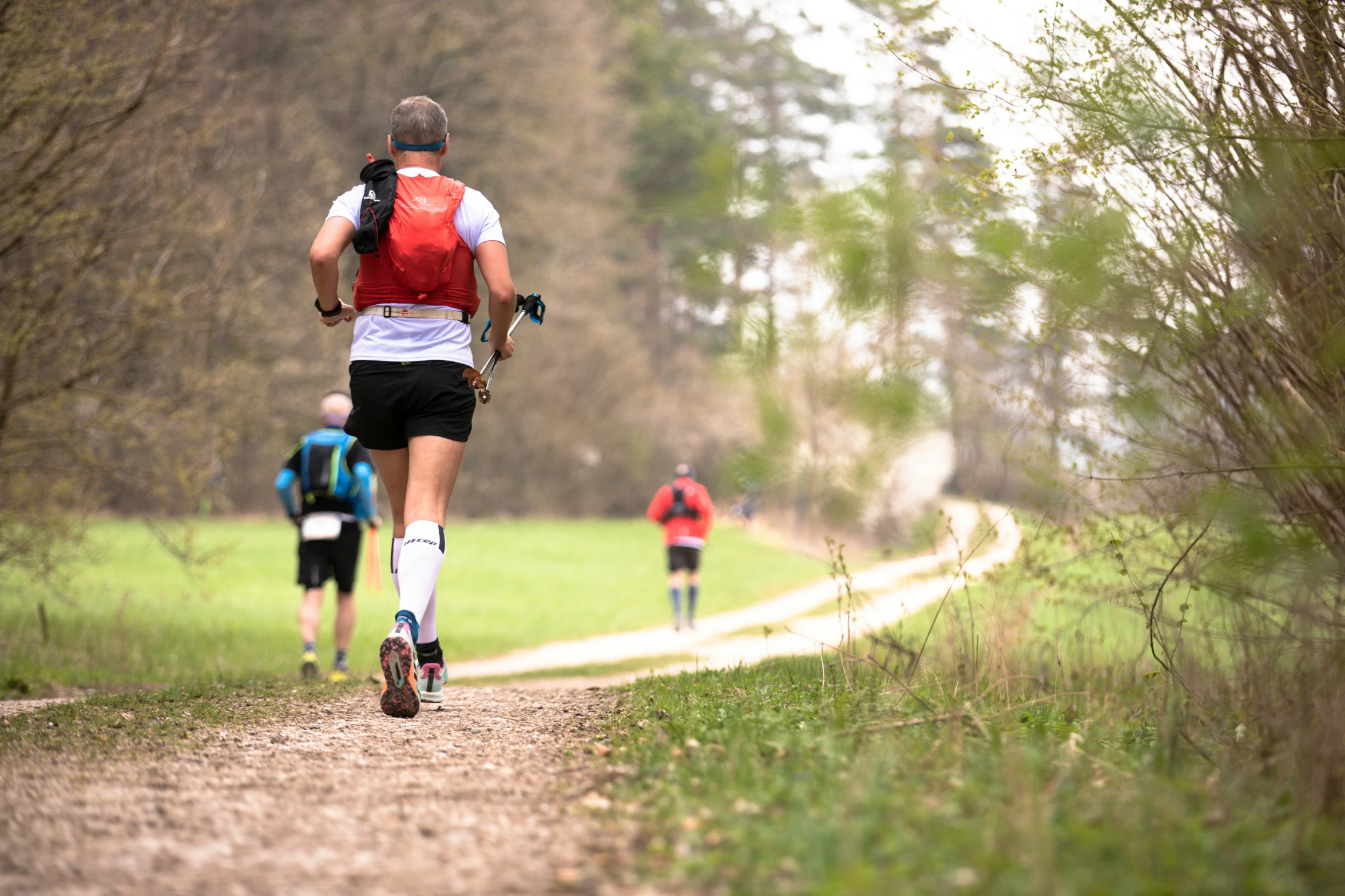 two people running on a road with hiking gear on