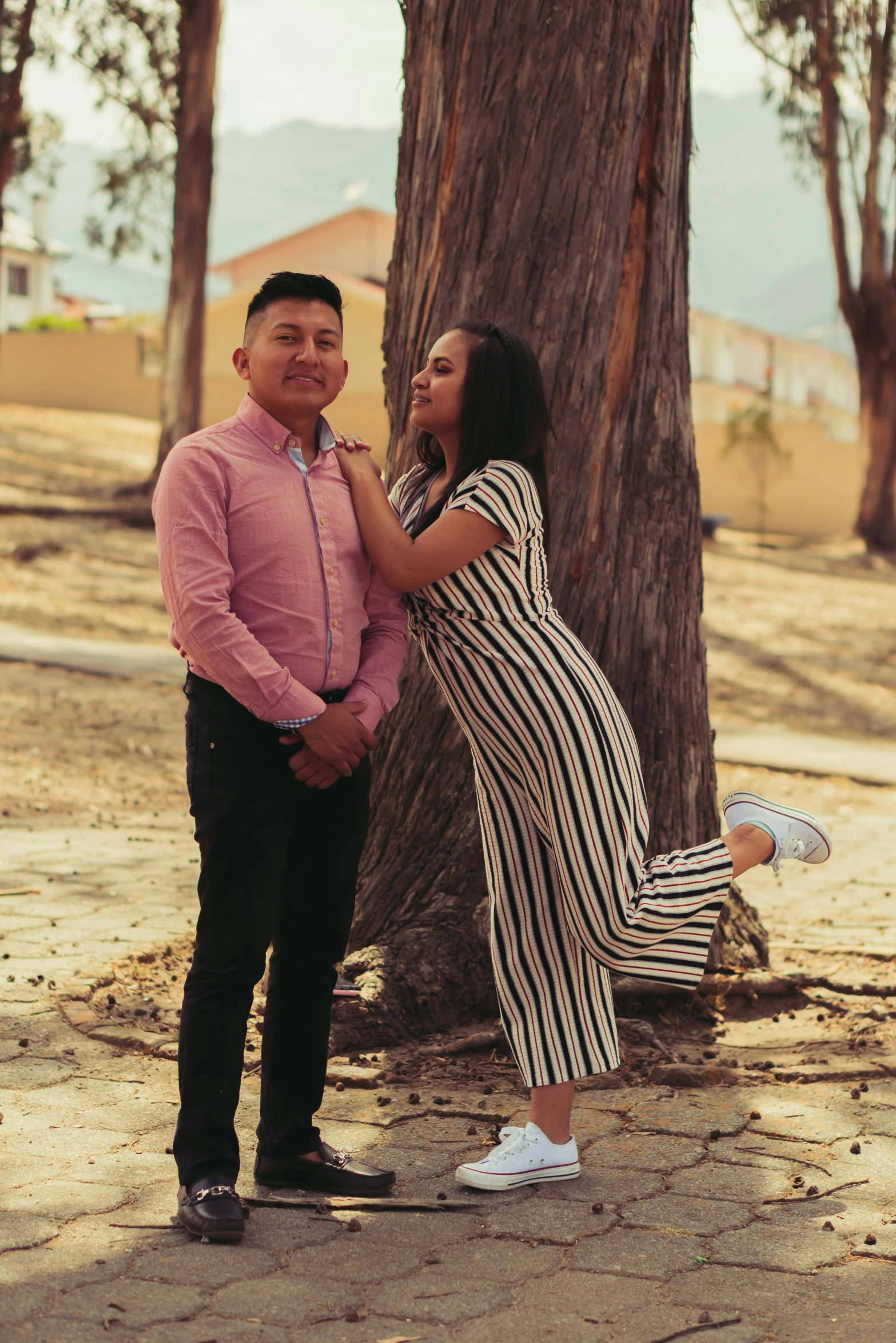 an asian couple in front of a large tree