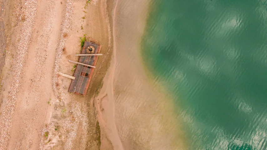 an aerial view of two boats on a beach near water