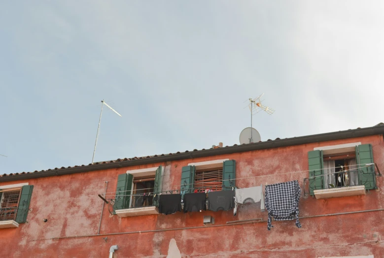 some clothes are hanging from the side of a building