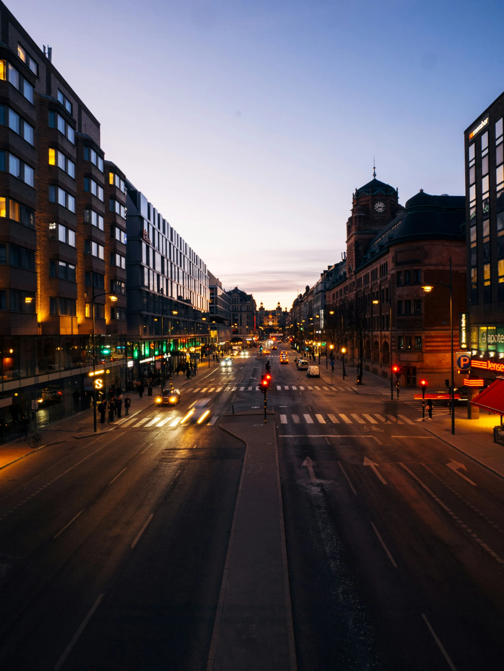 a city street at dusk with traffic lights