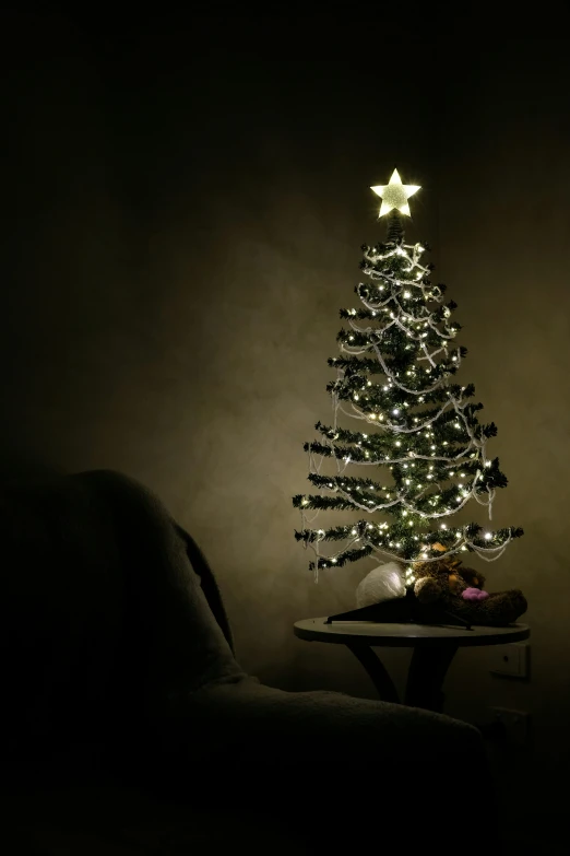 a lit christmas tree in the dark with stars on it