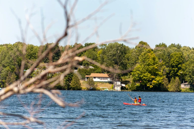 people are kayaking in a lake on a sunny day