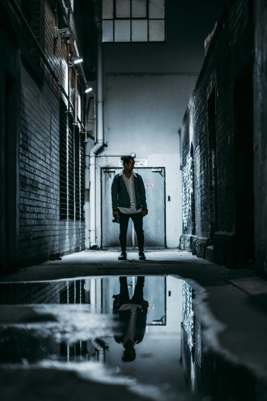 a man standing alone in a dark hallway