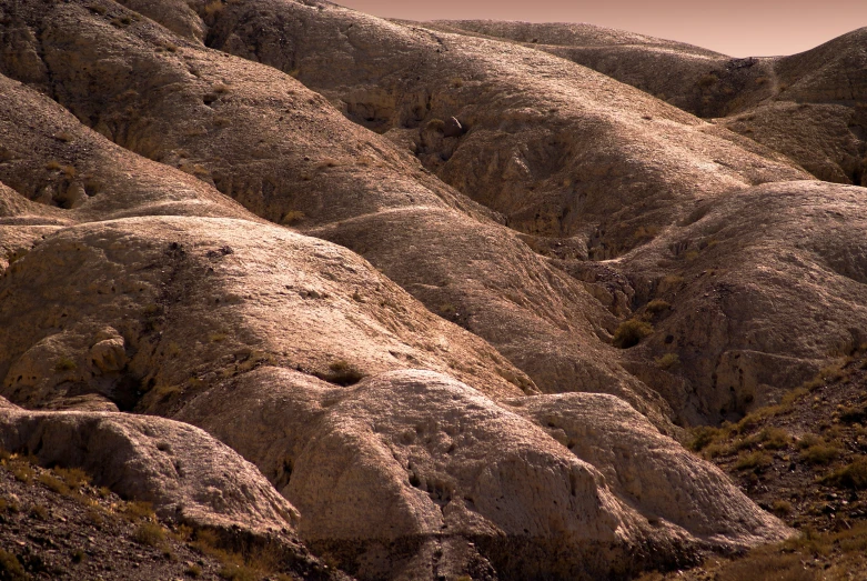 a large rocky mountain side is shown in the sunlight